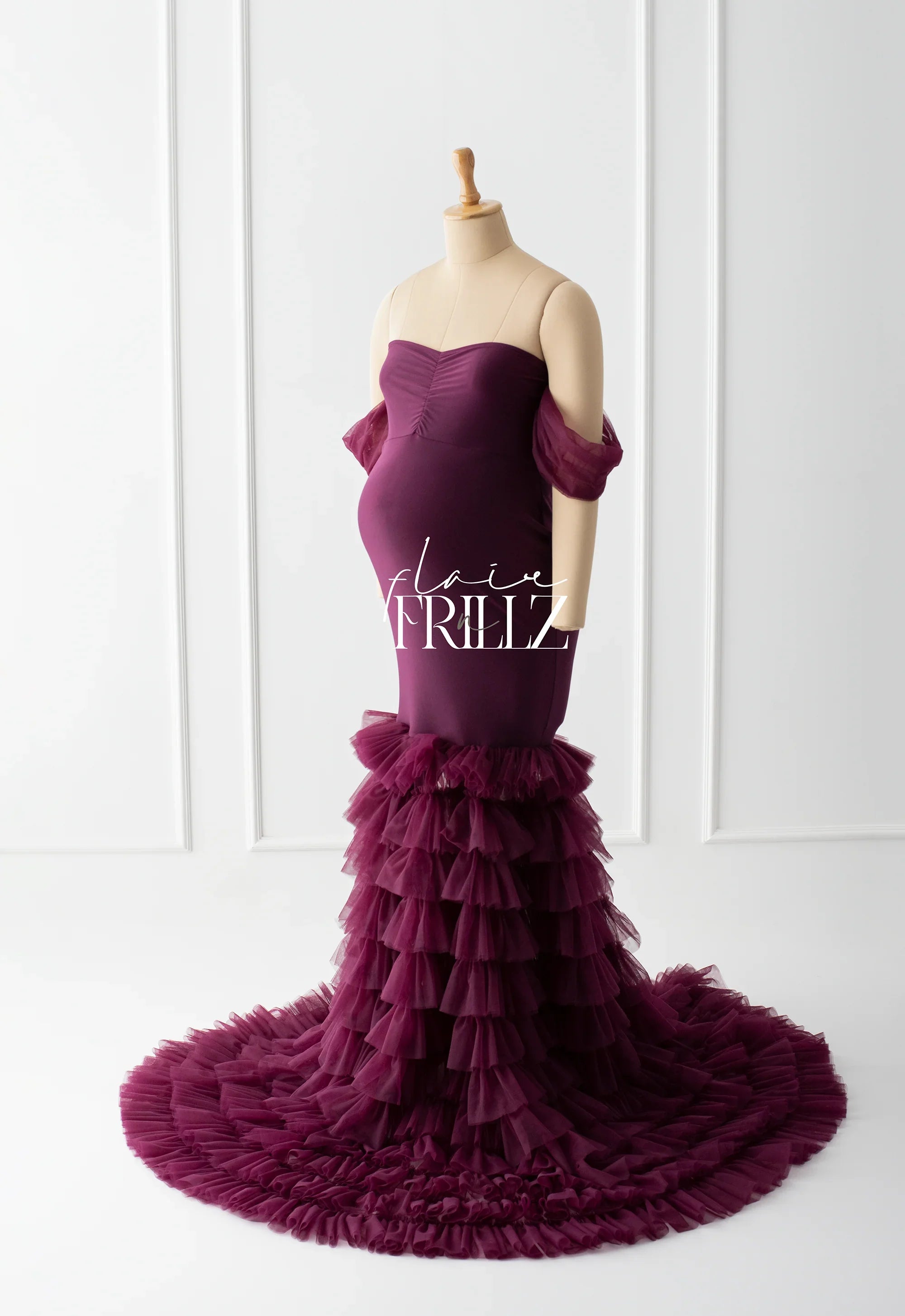 Burgundy off-shoulder maternity gown with ruffled tulle train on mannequin