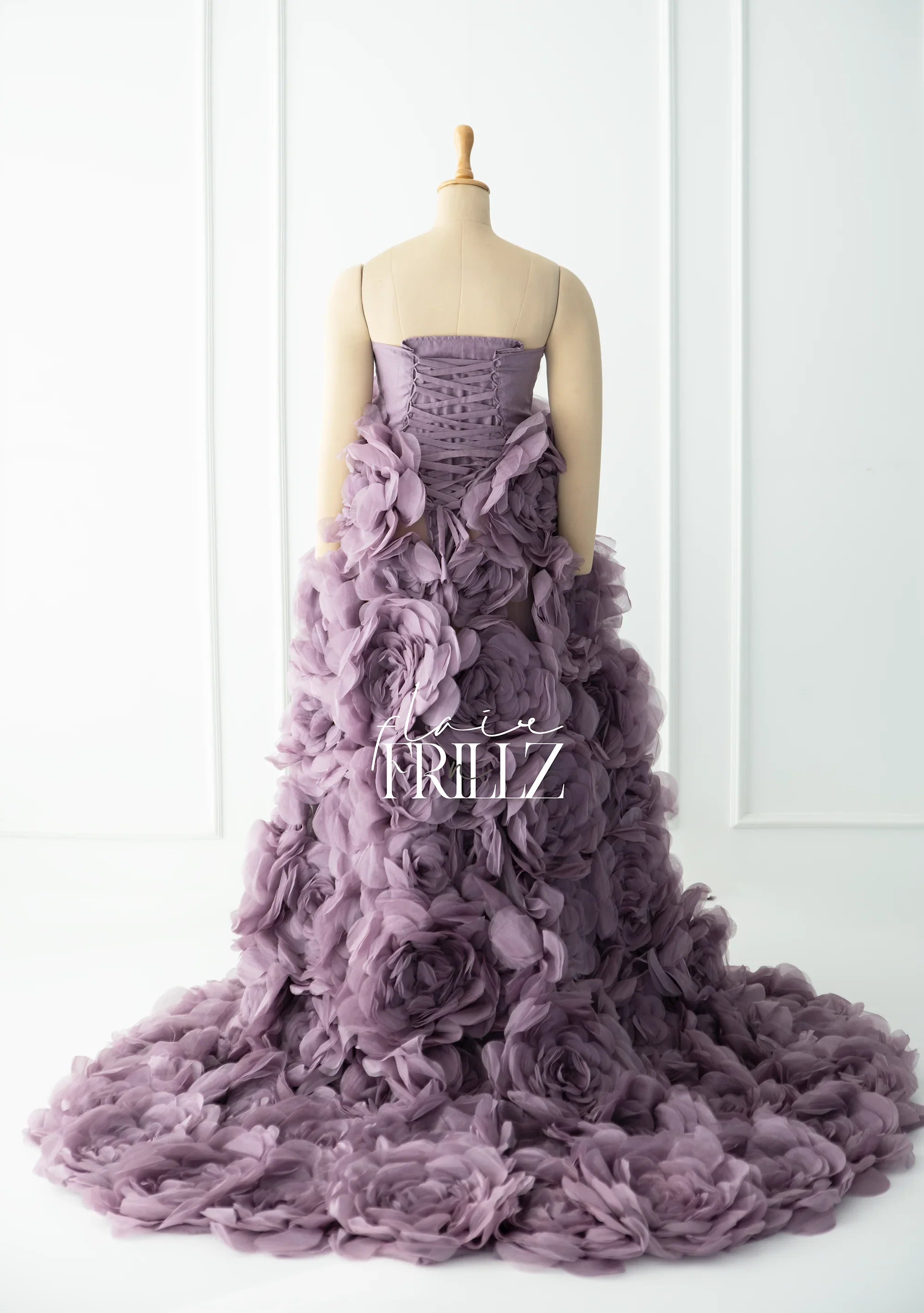 Back view of mauve maternity gown with 3D floral ruffles and corset bodice on mannequin
