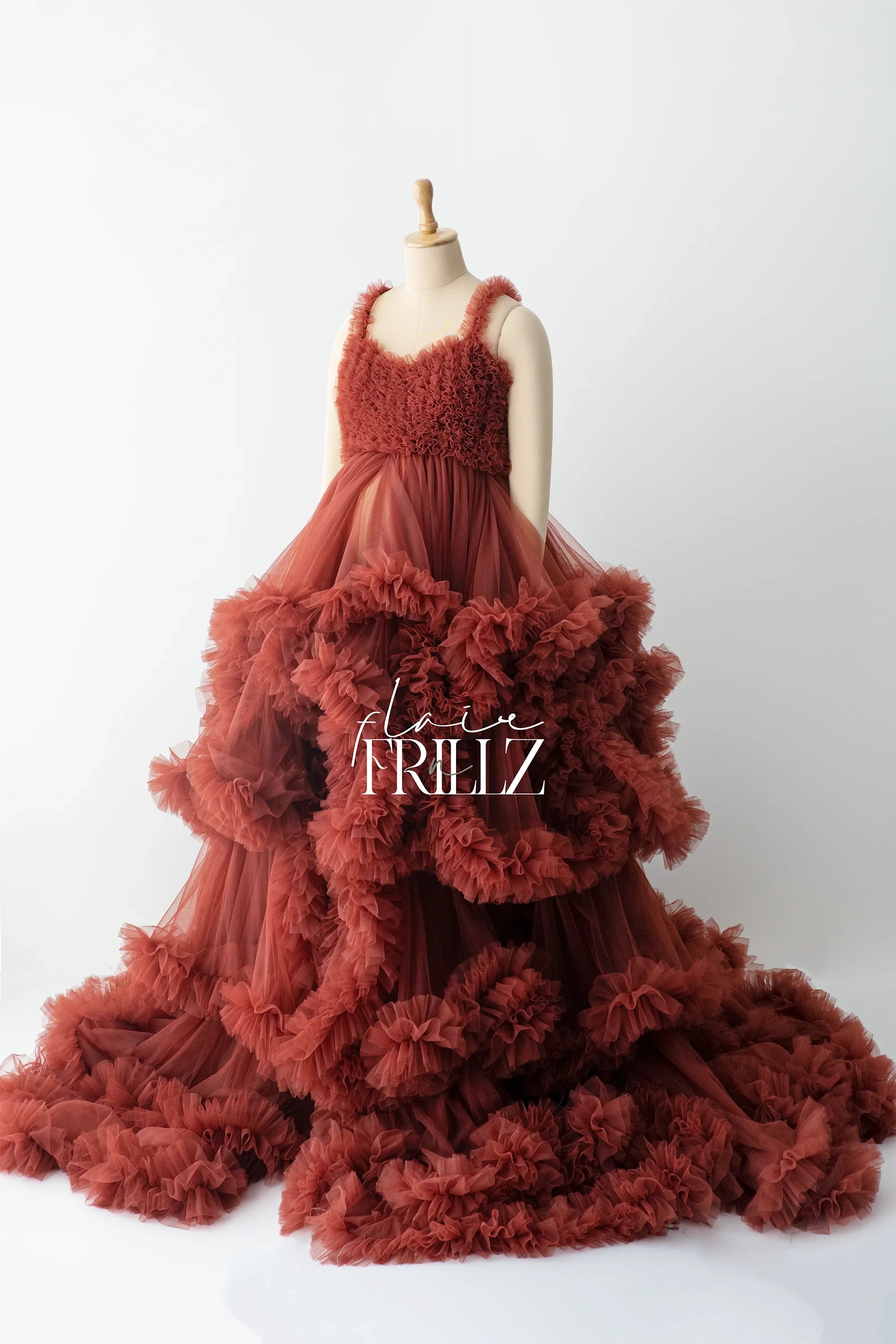 Maroon ruffle maternity gown with layered tulle skirt on mannequin