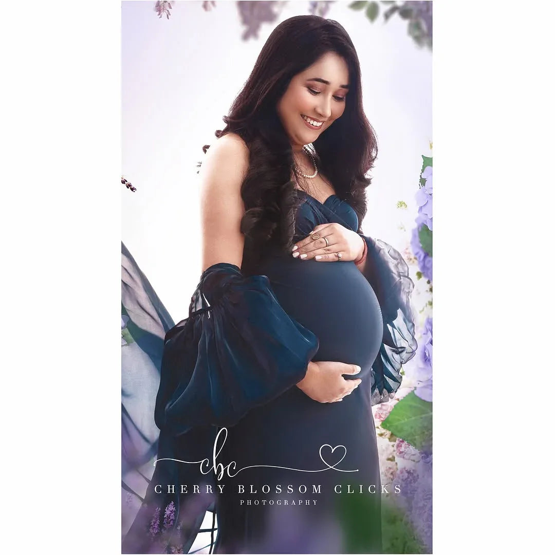 Lyla Blue Maternity Dress Gown by FlairNFrillz, flowing fabric with a fitted waist, perfect for expecting mothers, shown on a hanger.