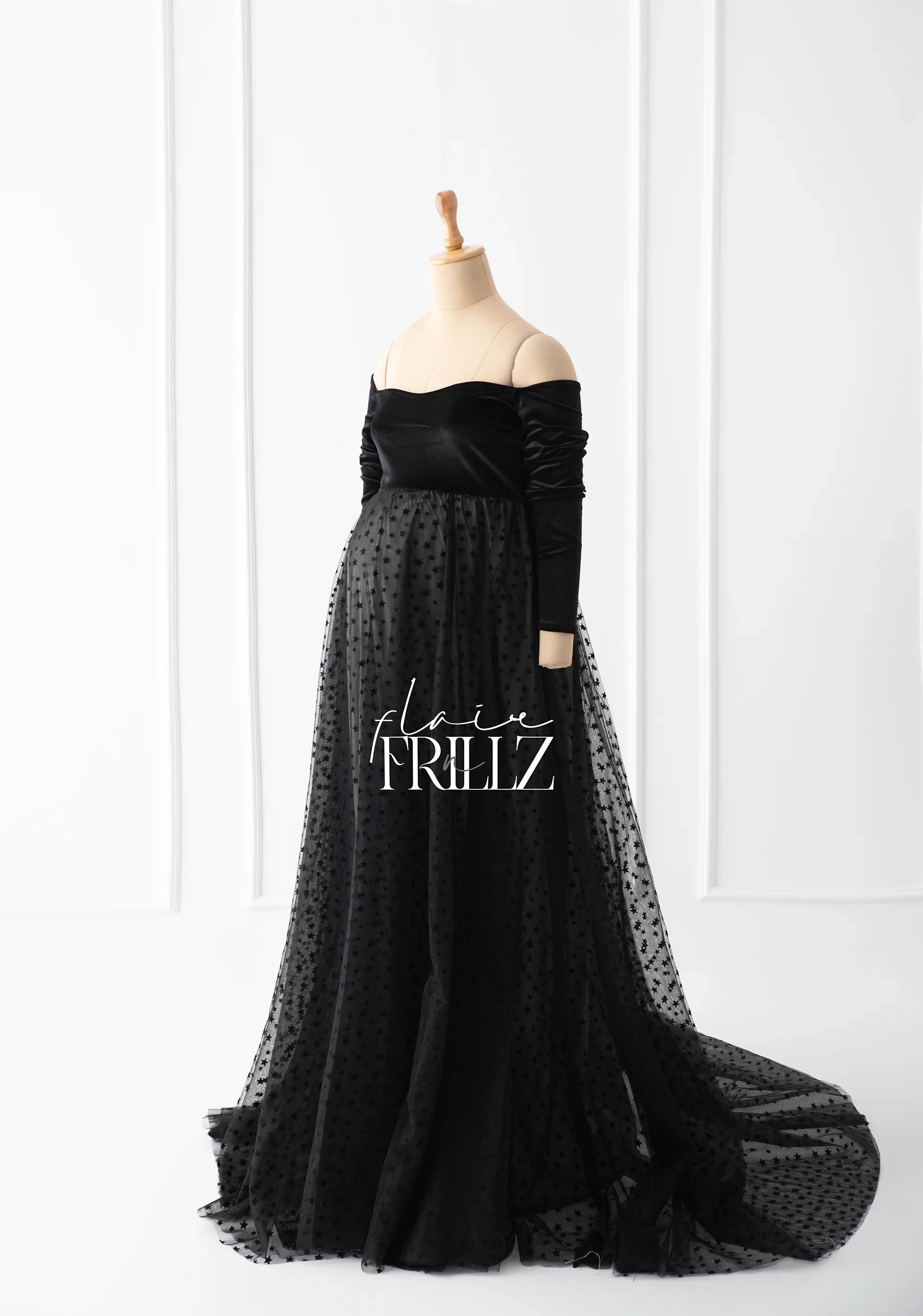 Black maternity gown with off-shoulder velvet bodice and sheer polka dot tulle skirt on mannequin
