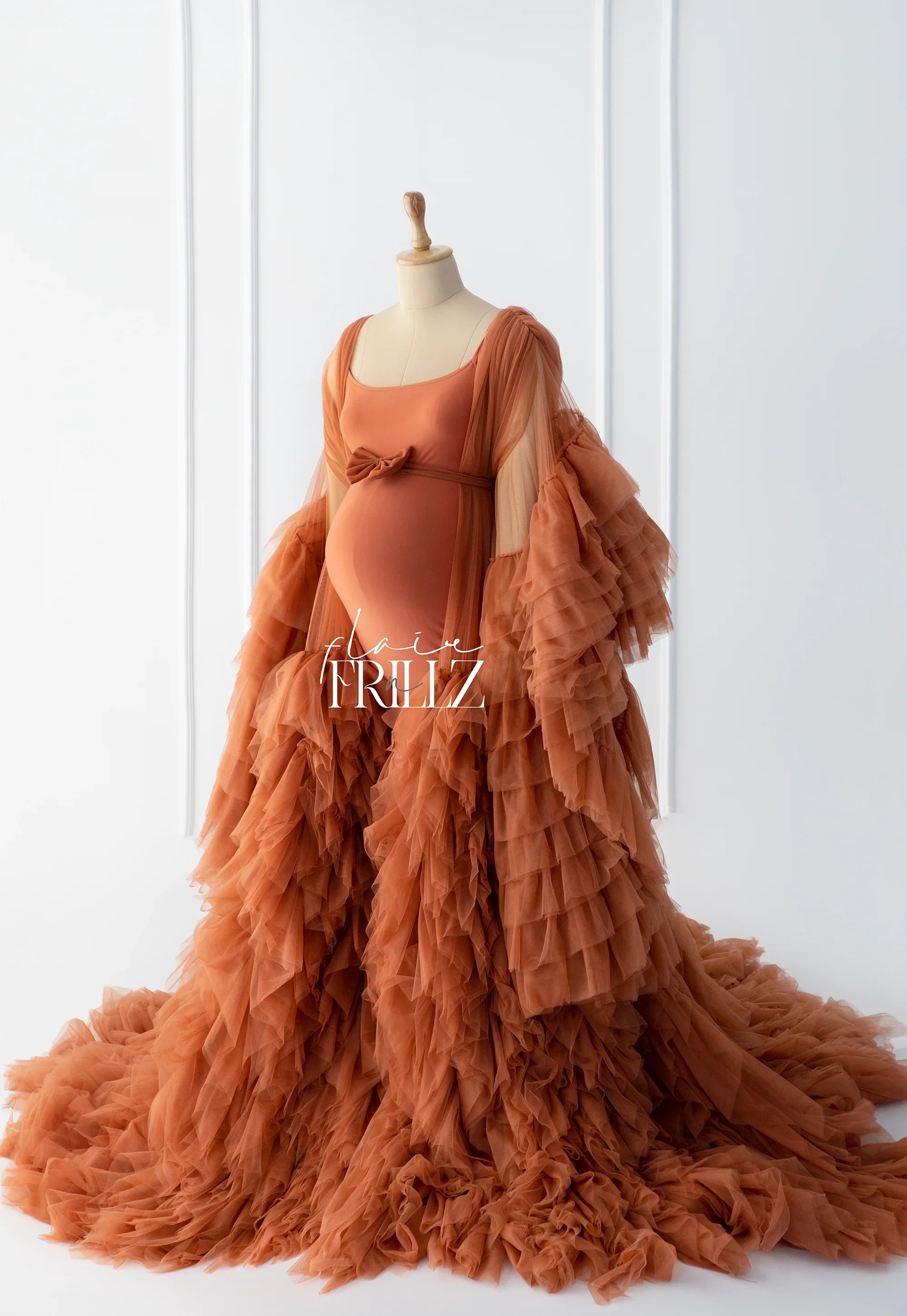 Rust orange ruffled maternity robe gown with sheer sleeves on dress form in studio setting