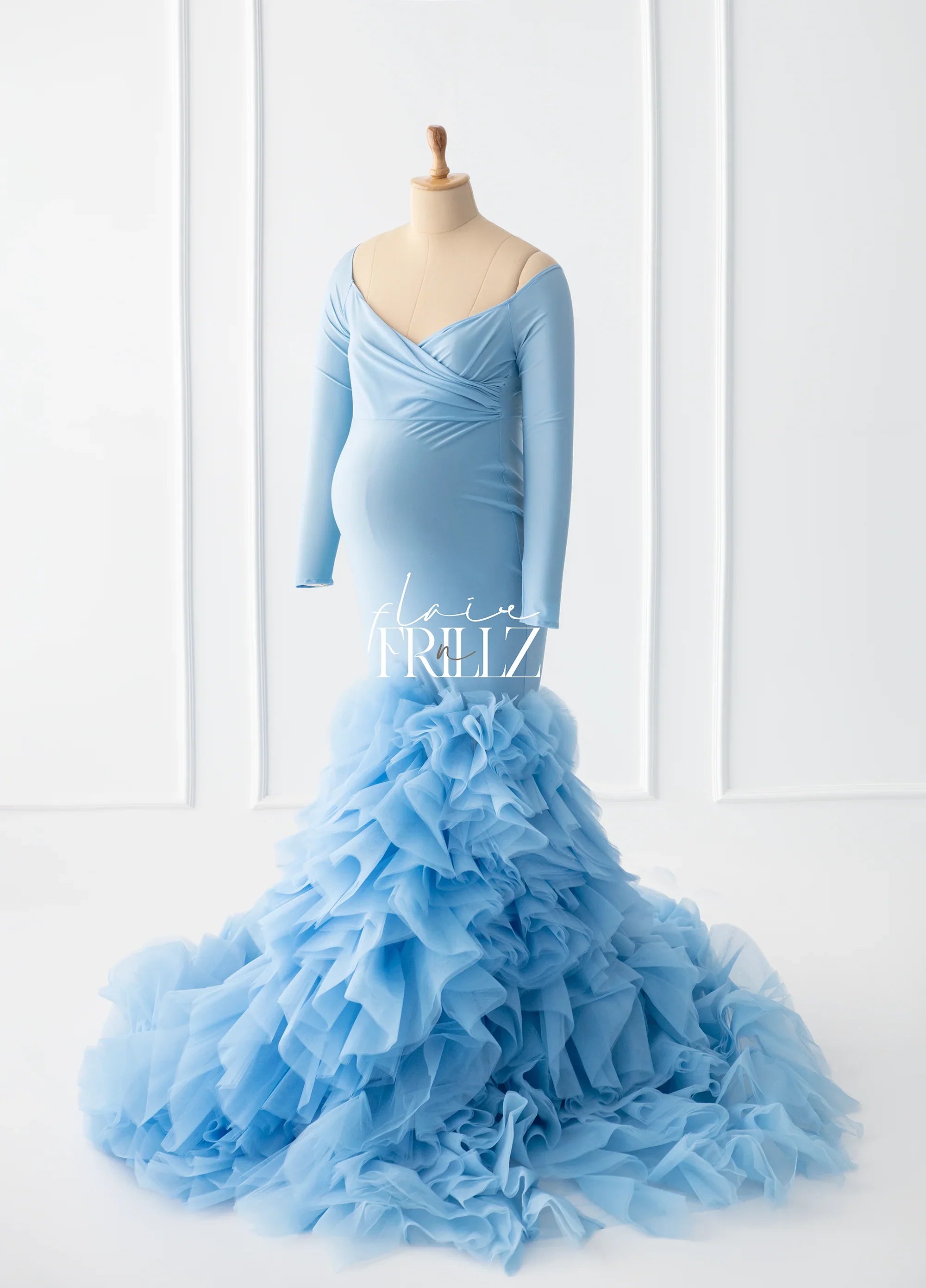 Light blue long sleeve maternity gown with ruffled tulle skirt on dress form