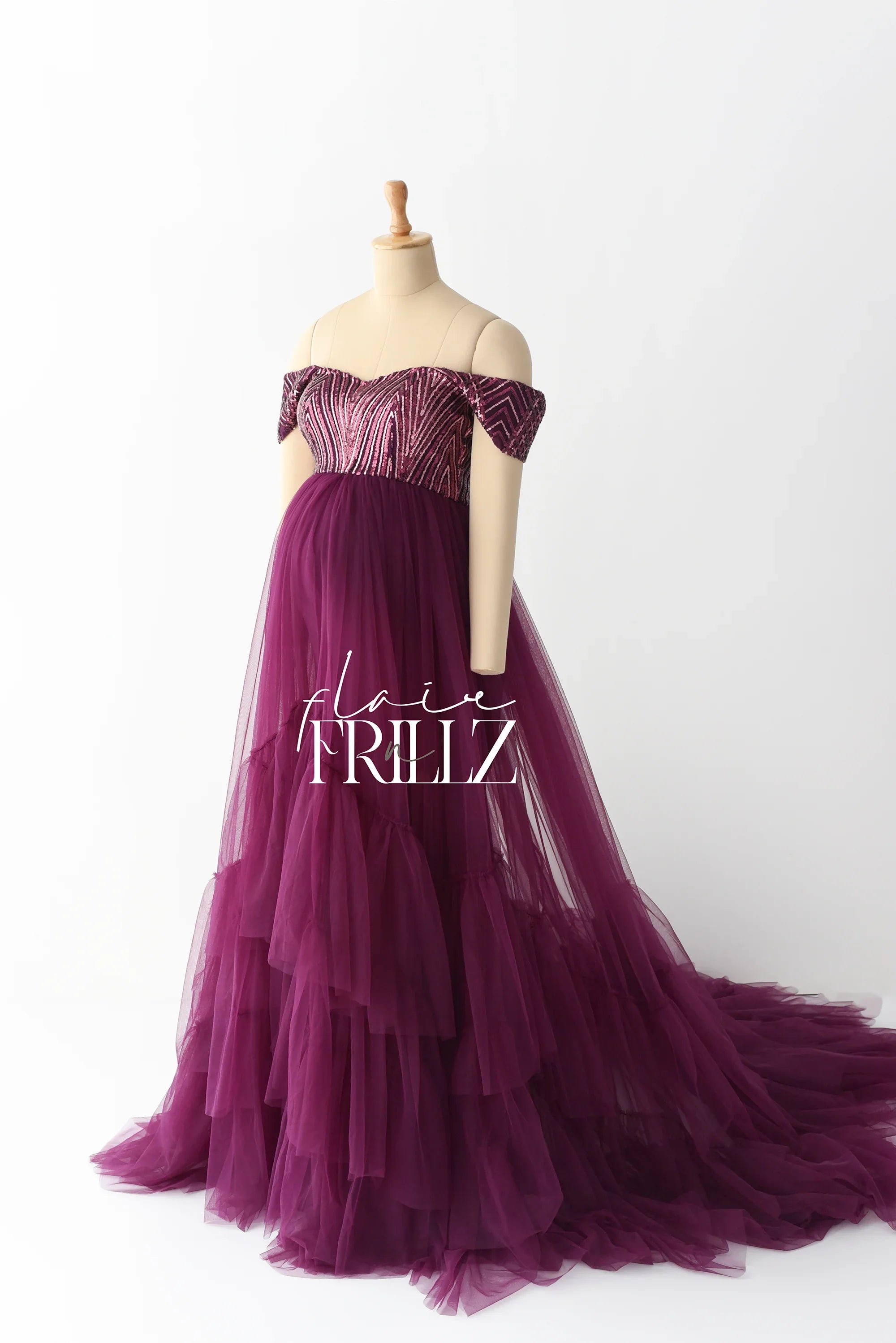 Purple off shoulder maternity gown with sequin bodice and layered tulle skirt on mannequin
