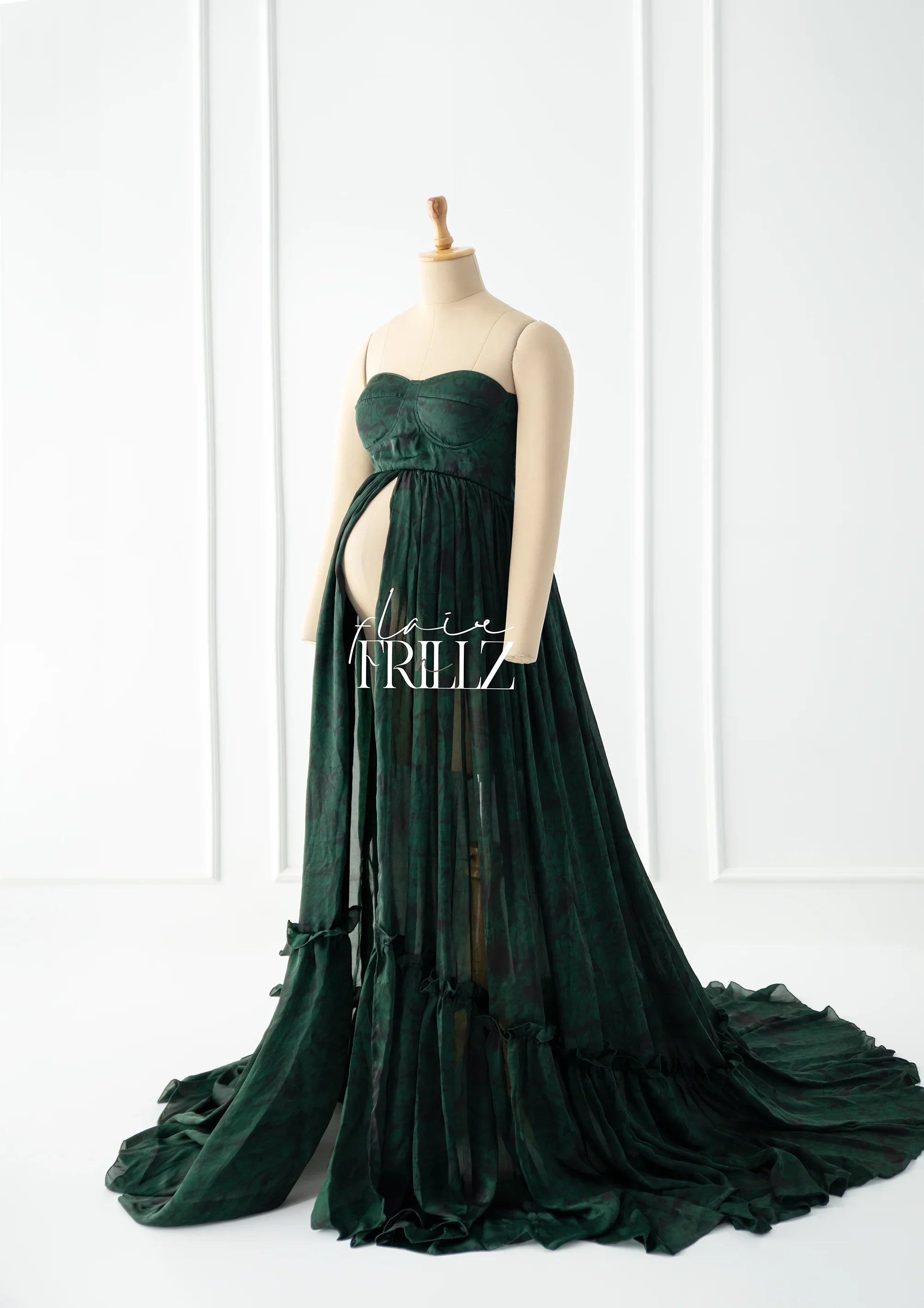 Dark green printed maternity gown with strapless sweetheart neckline and flowing train on mannequin