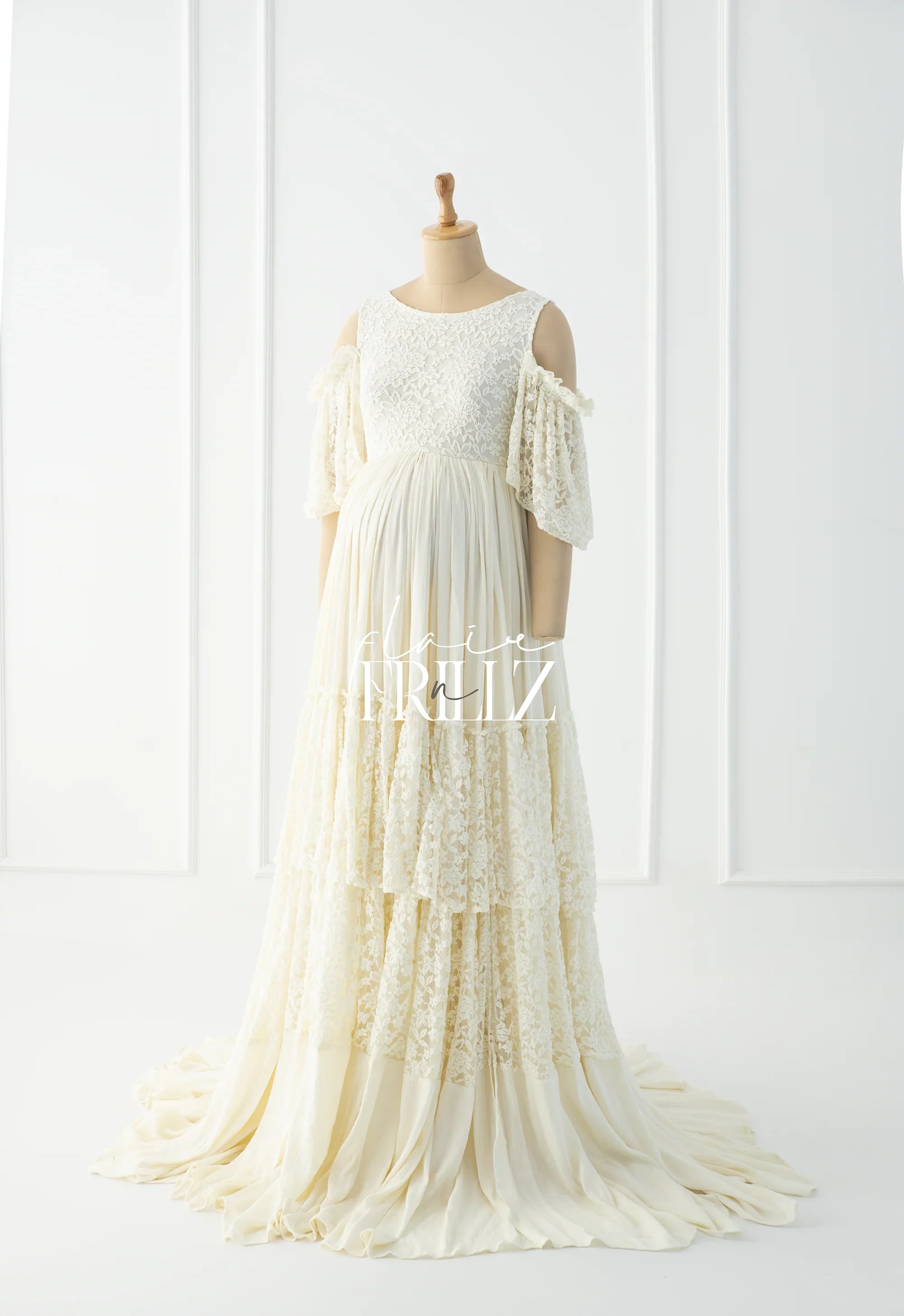 Ivory boho lace maternity gown with tiered skirt and flutter sleeves on mannequin