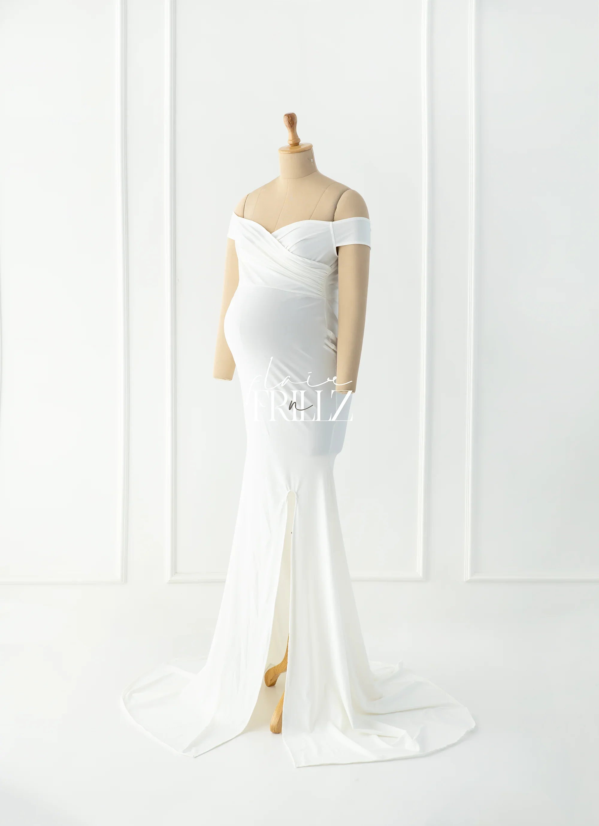 White off-shoulder maternity gown with floor-length train and front slit on mannequin