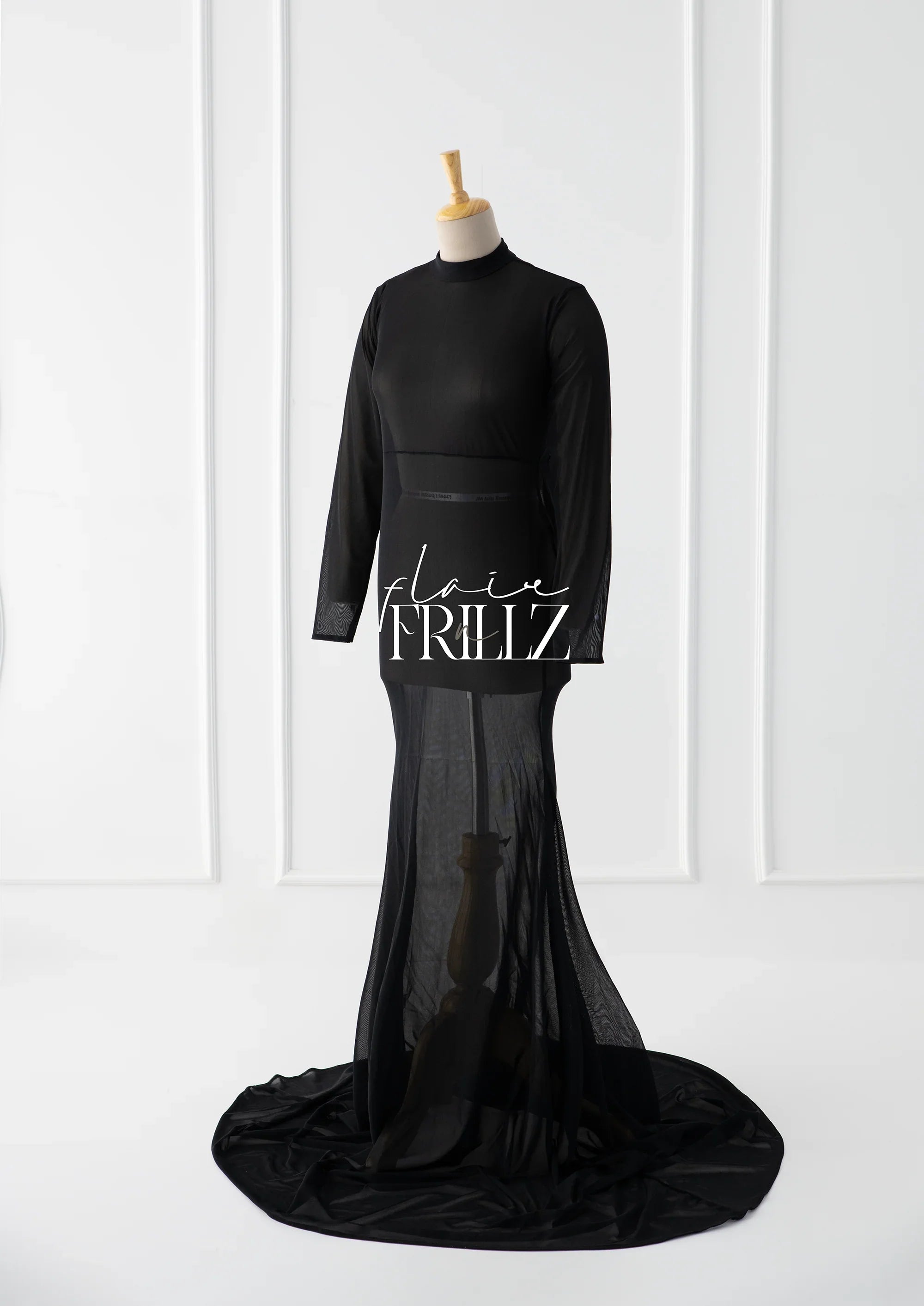 Elegant black maternity gown with long sleeves and sheer train on mannequin