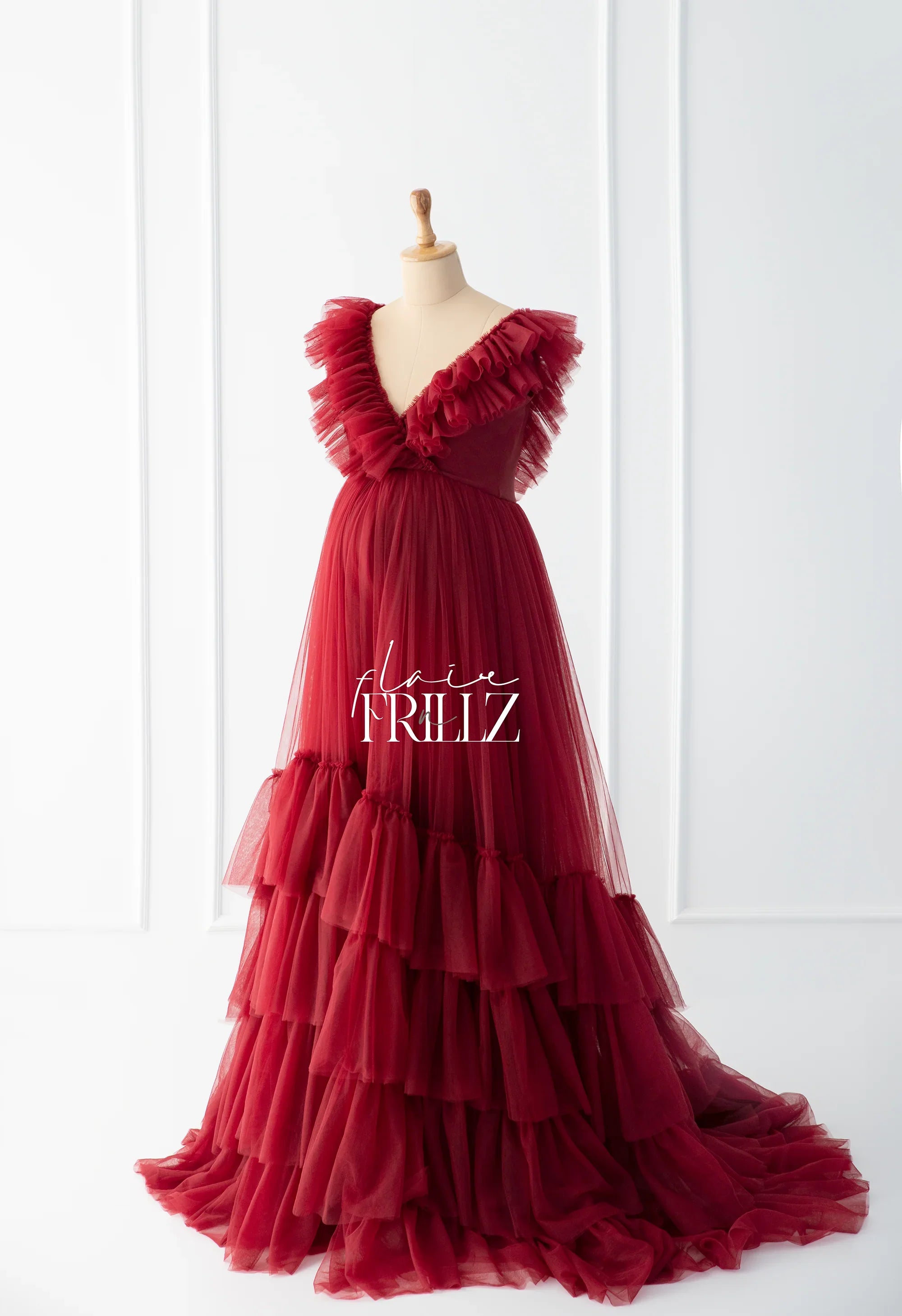 Elegant maroon maternity gown with layered ruffles on a dress form, tulle fabric, V-neck