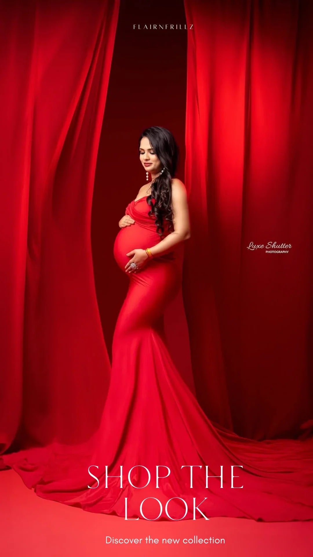 Pregnant woman in elegant red maternity gown posing against red draped backdrop