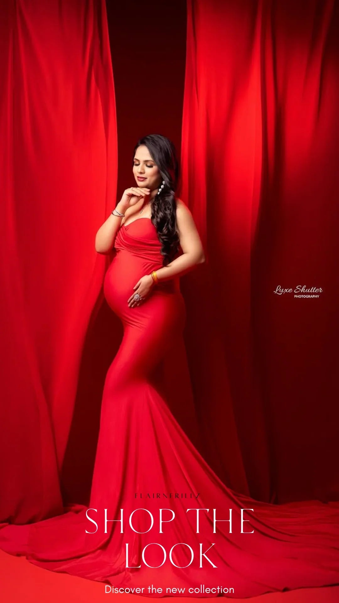 Pregnant woman in elegant red maternity gown posing against matching red drapes backdrop