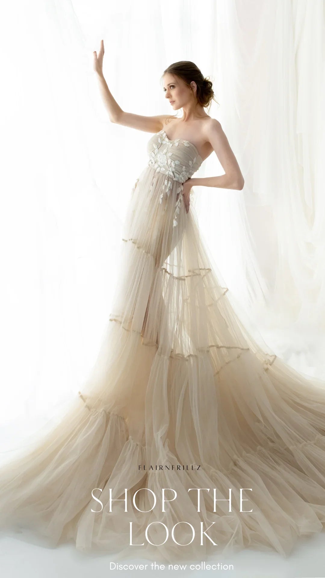 Woman in elegant beige strapless maternity gown with tulle layers in a bright studio