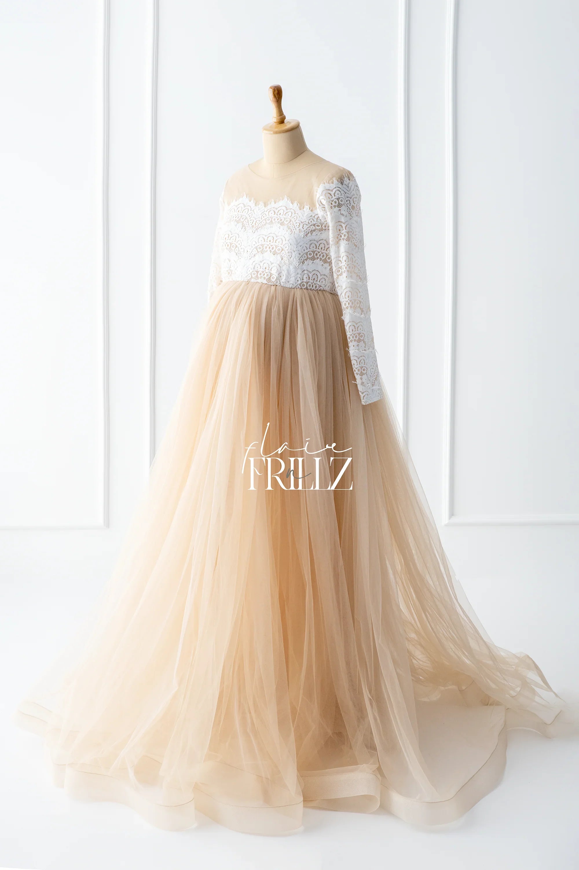 Elegant maternity gown with lace bodice and long tulle skirt on mannequin
