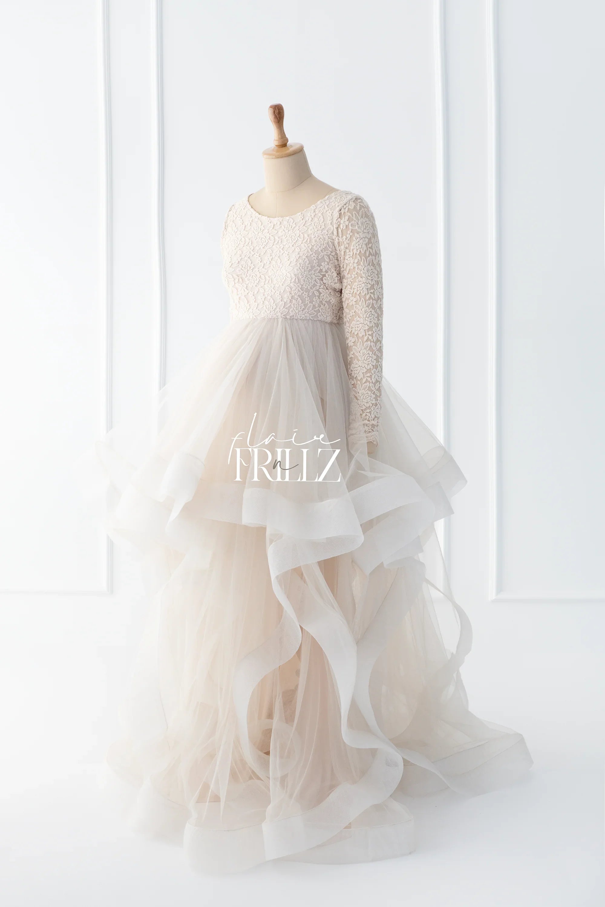 Ivory lace maternity gown with long sleeves and layered tulle skirt on dress form