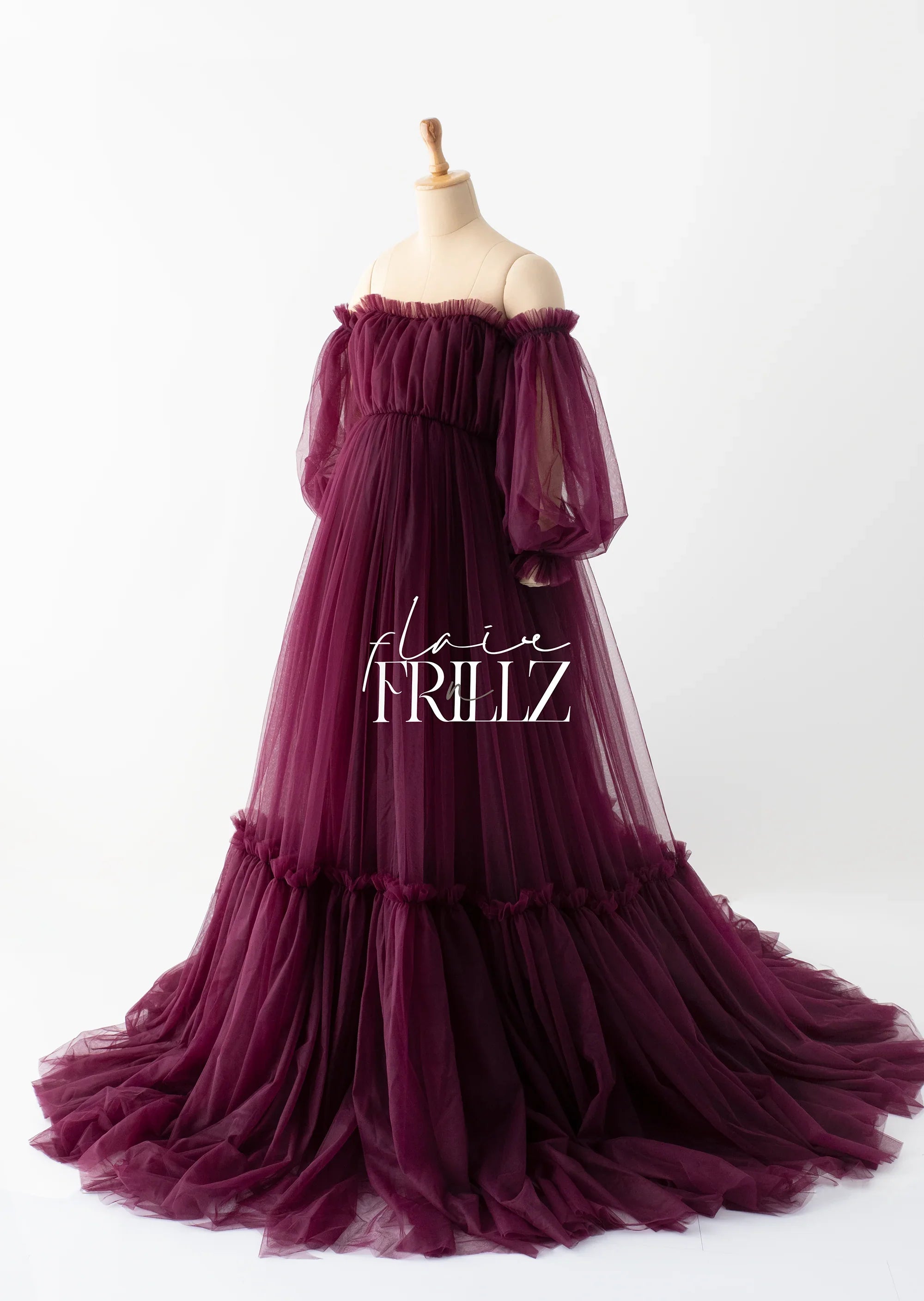 Elegant burgundy off-shoulder tulle maternity gown with puff sleeves on mannequin