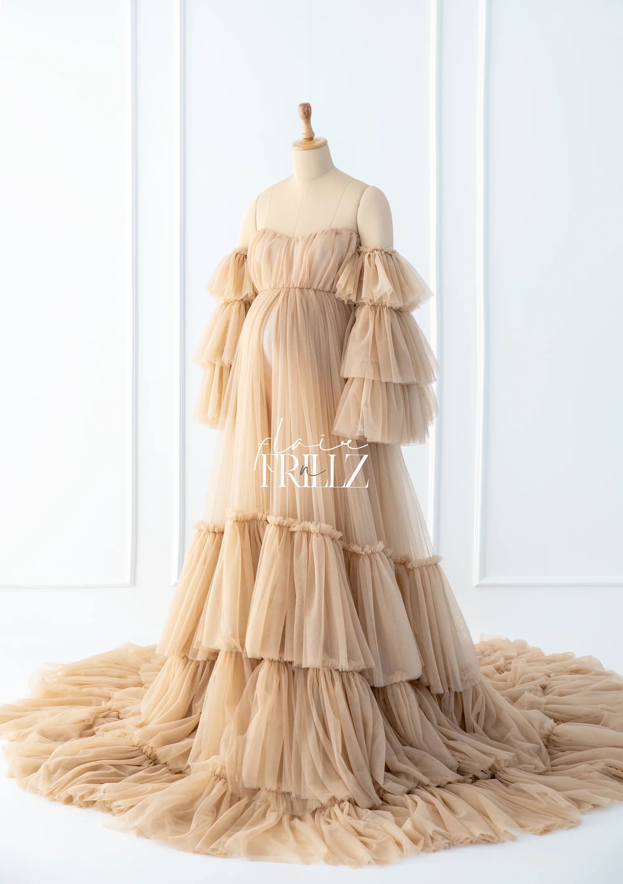 Beige tiered ruffled maternity gown with off-shoulder sleeves on mannequin