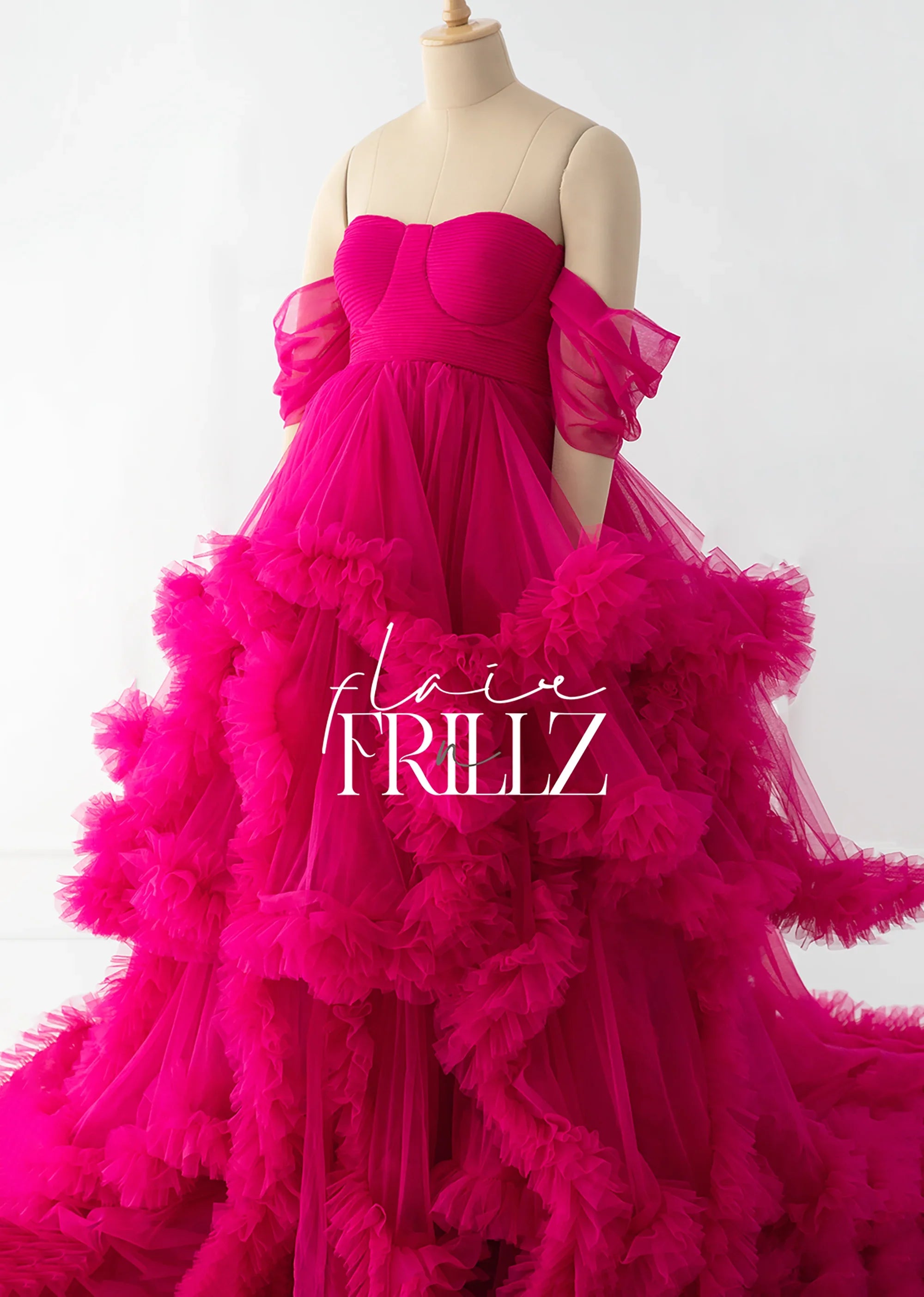 Fuchsia ruffled maternity gown with off-shoulder tulle sleeves on dress form