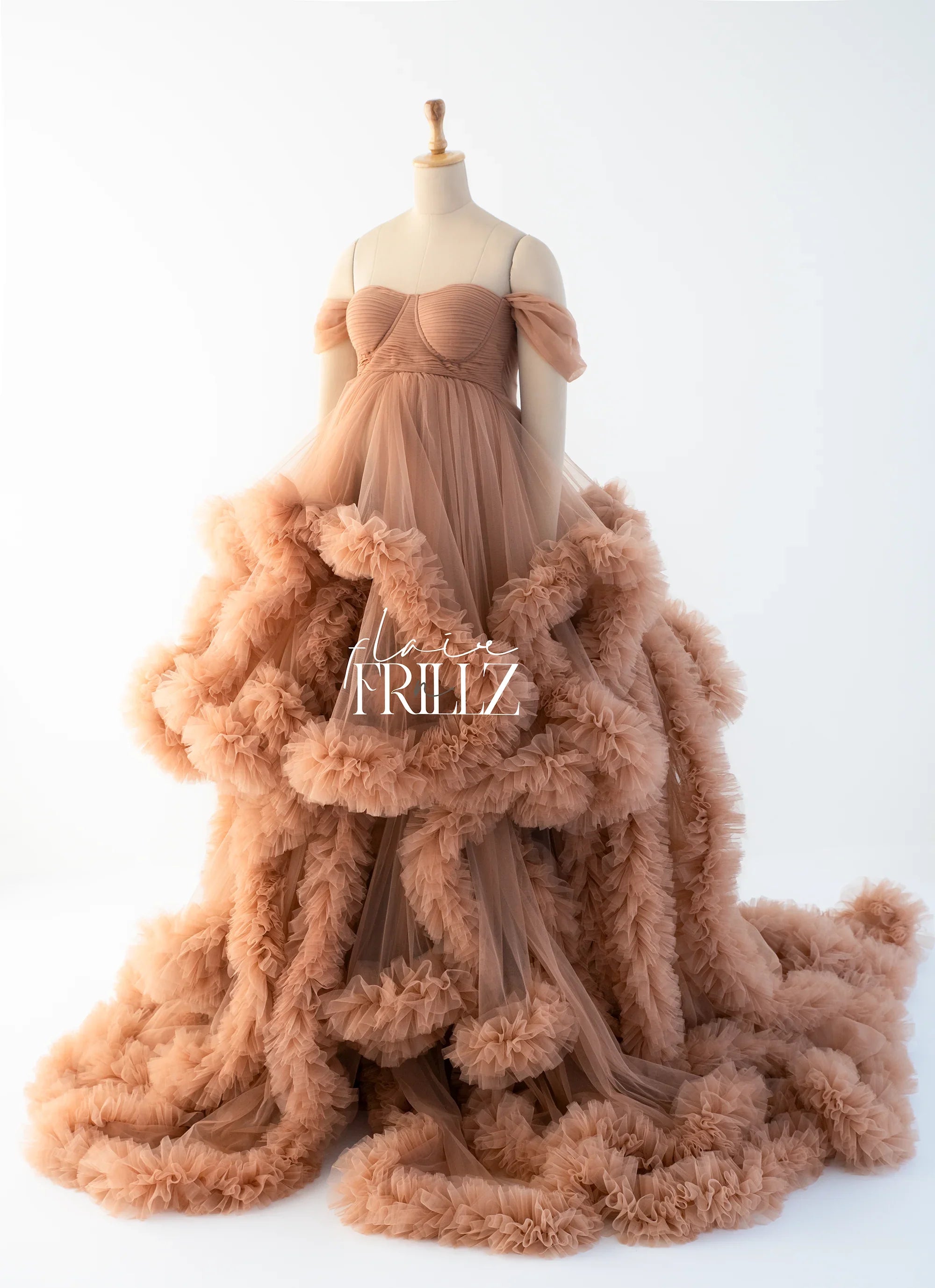 Rust tulle maternity gown with ruffled off-shoulder sleeves on mannequin
