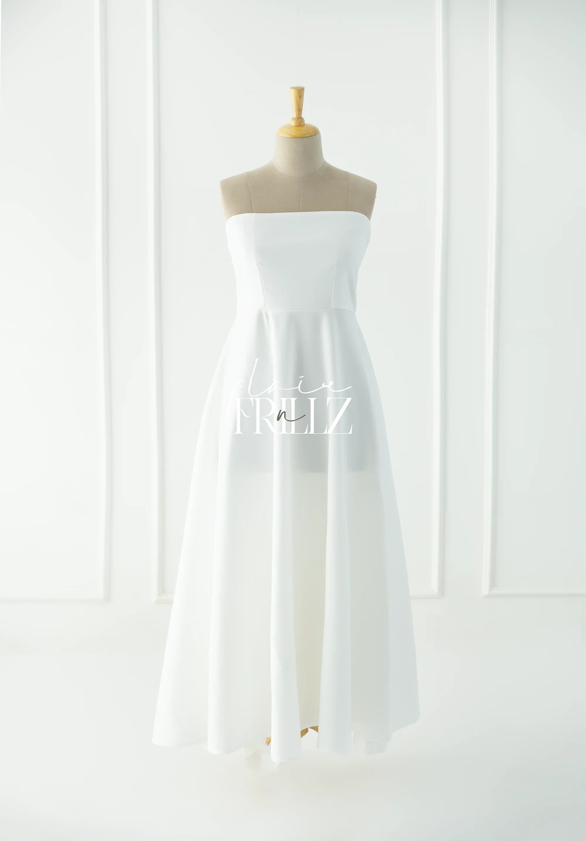 Strapless white maternity gown on mannequin in bright minimalist setting