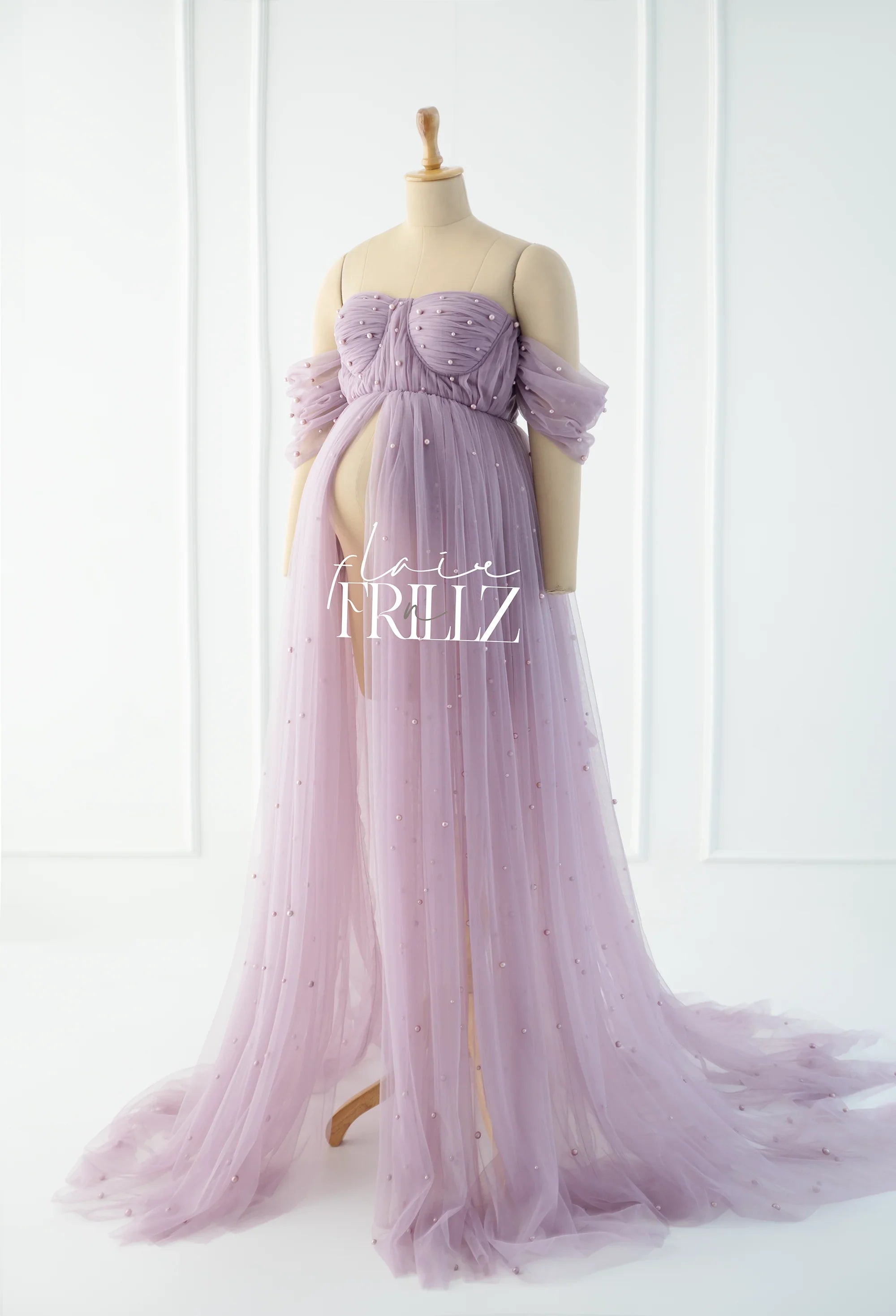 Lilac tulle maternity gown with off-shoulder sleeves and pearl embellishments on mannequin