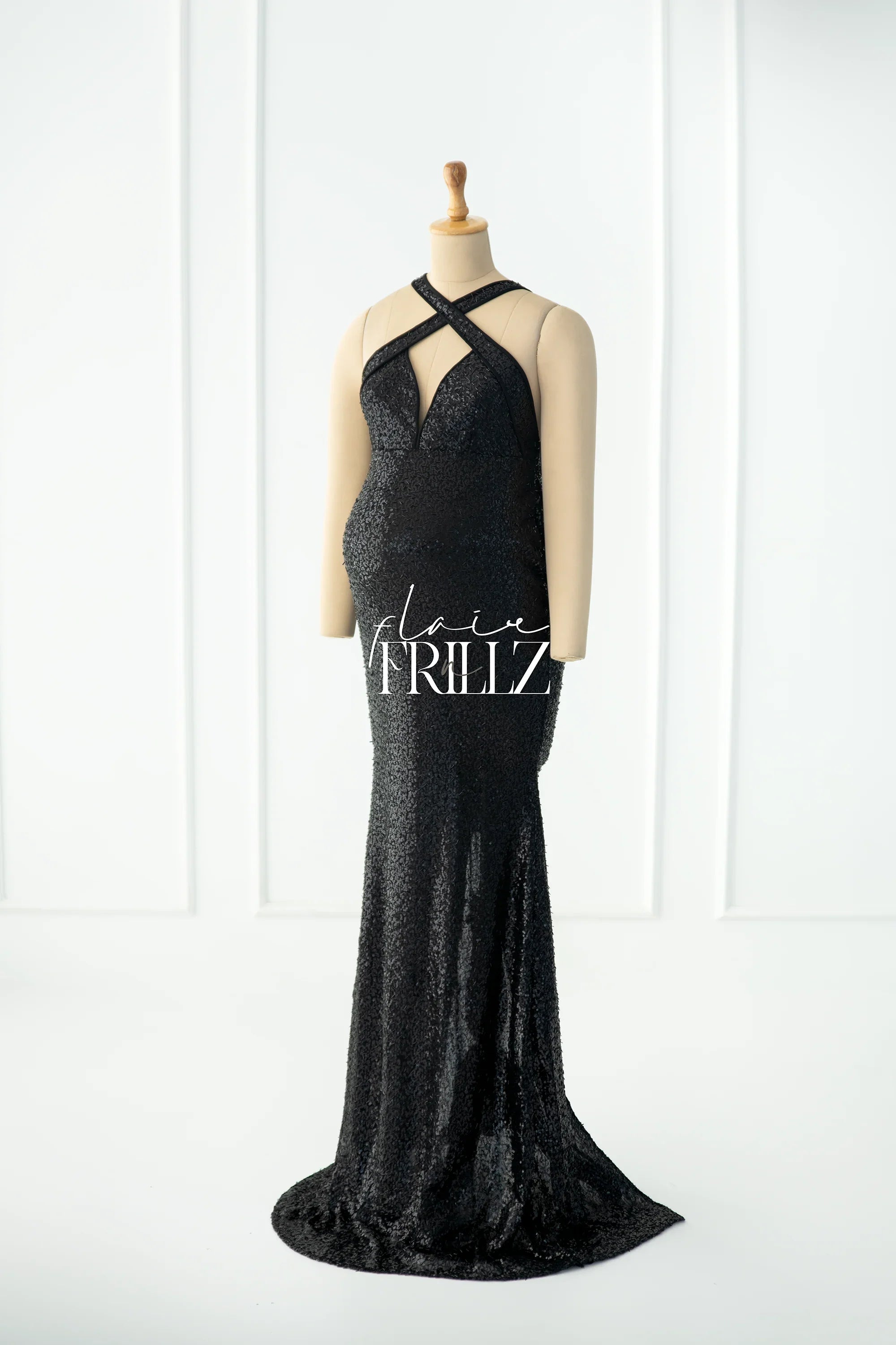 Black sequin maternity gown with cross halter neckline on mannequin, floor-length design