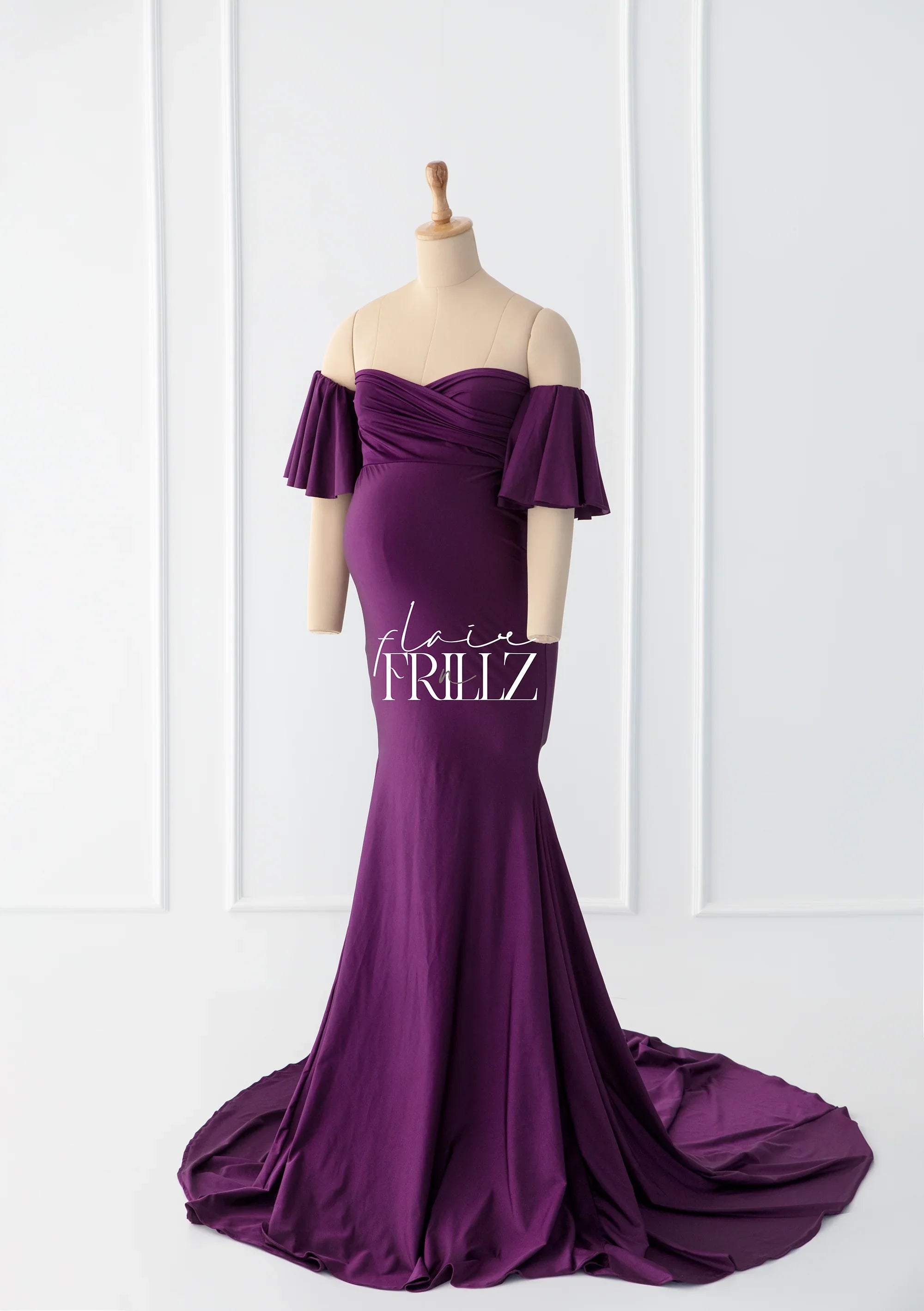 Purple off-shoulder maternity gown with flared sleeves and a long flowing train on a mannequin