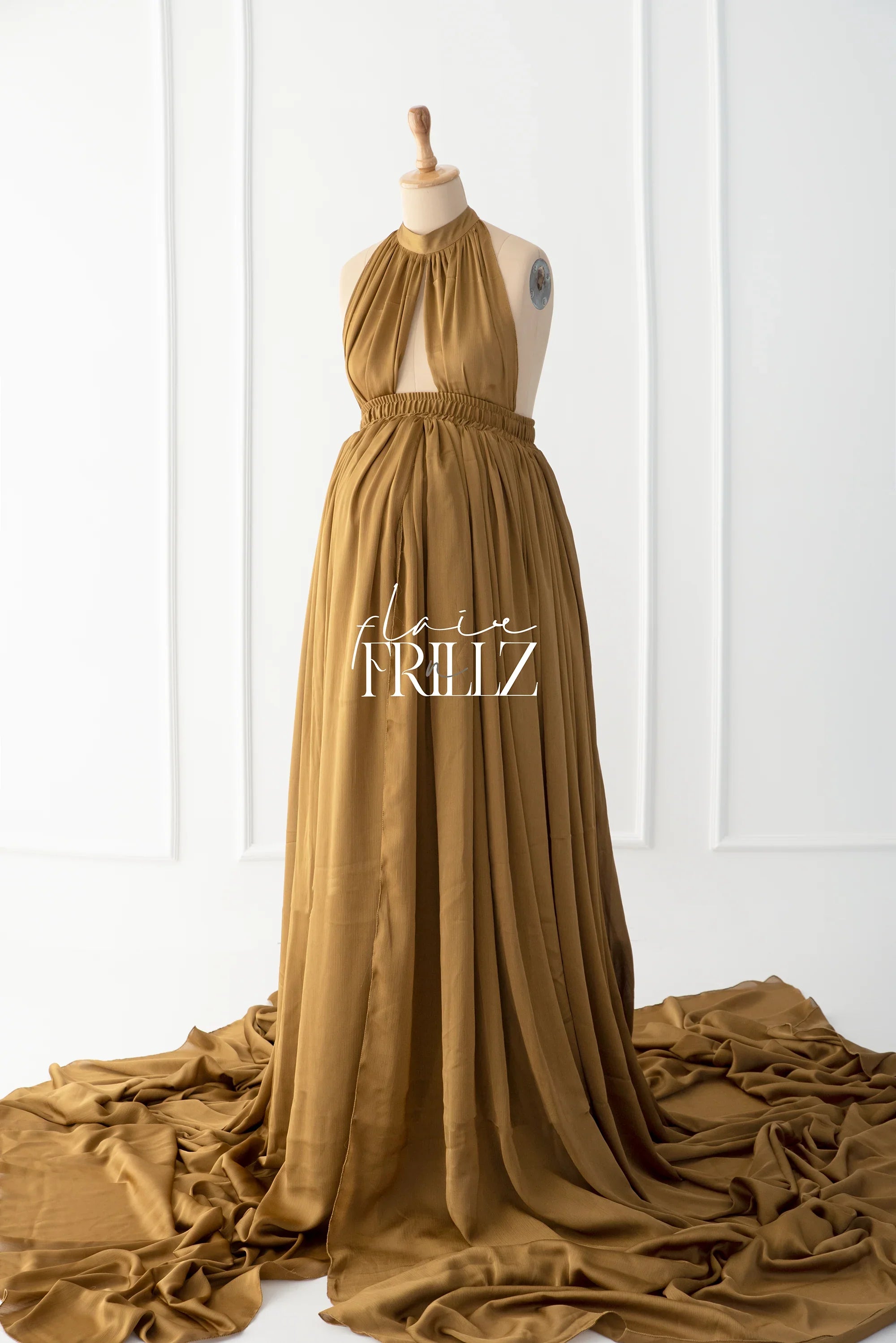 Tan halter-neck maternity gown with flowing skirt displayed on mannequin
