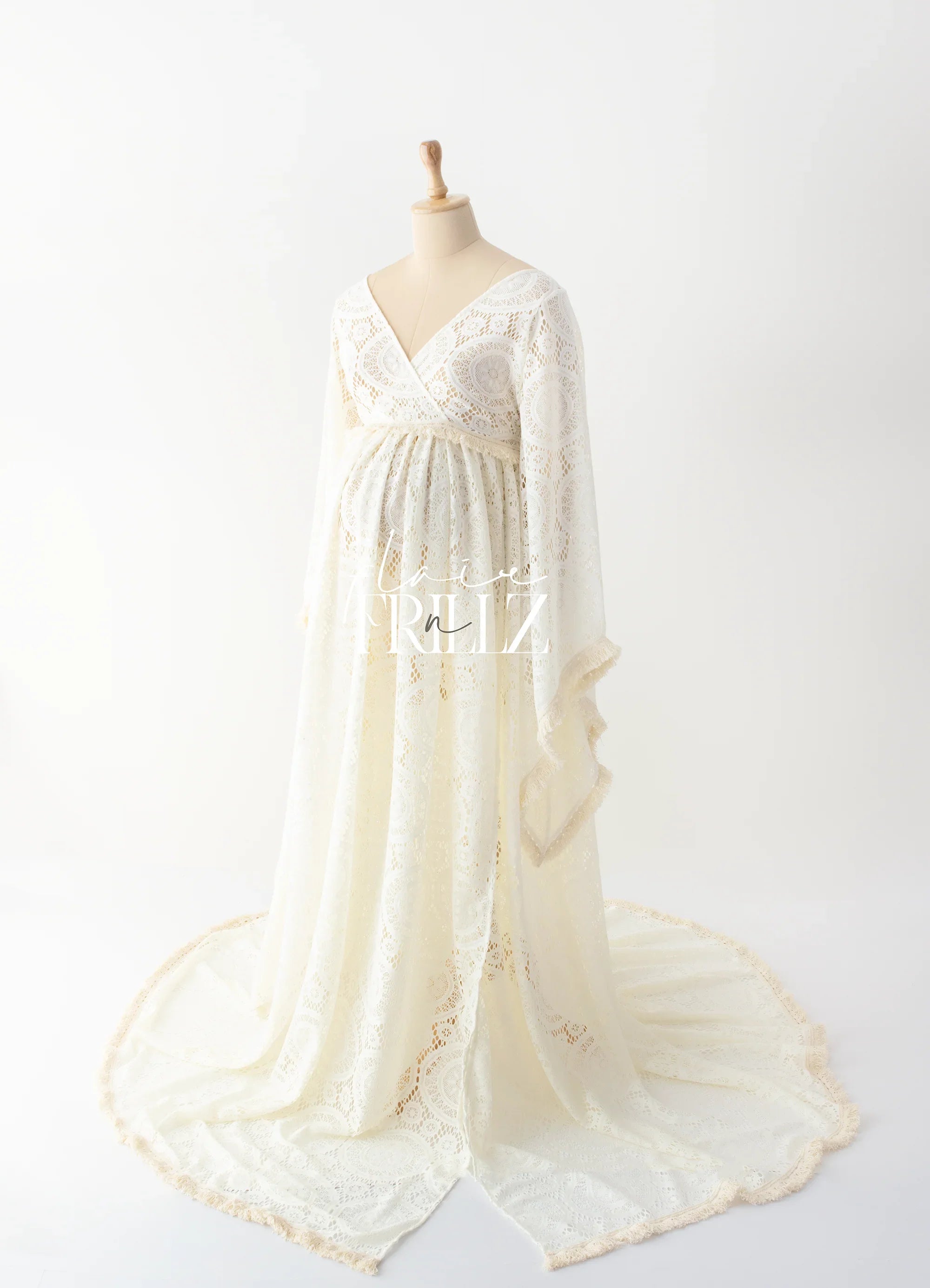 Ivory lace maternity gown with long sleeves and a flowing train on mannequin